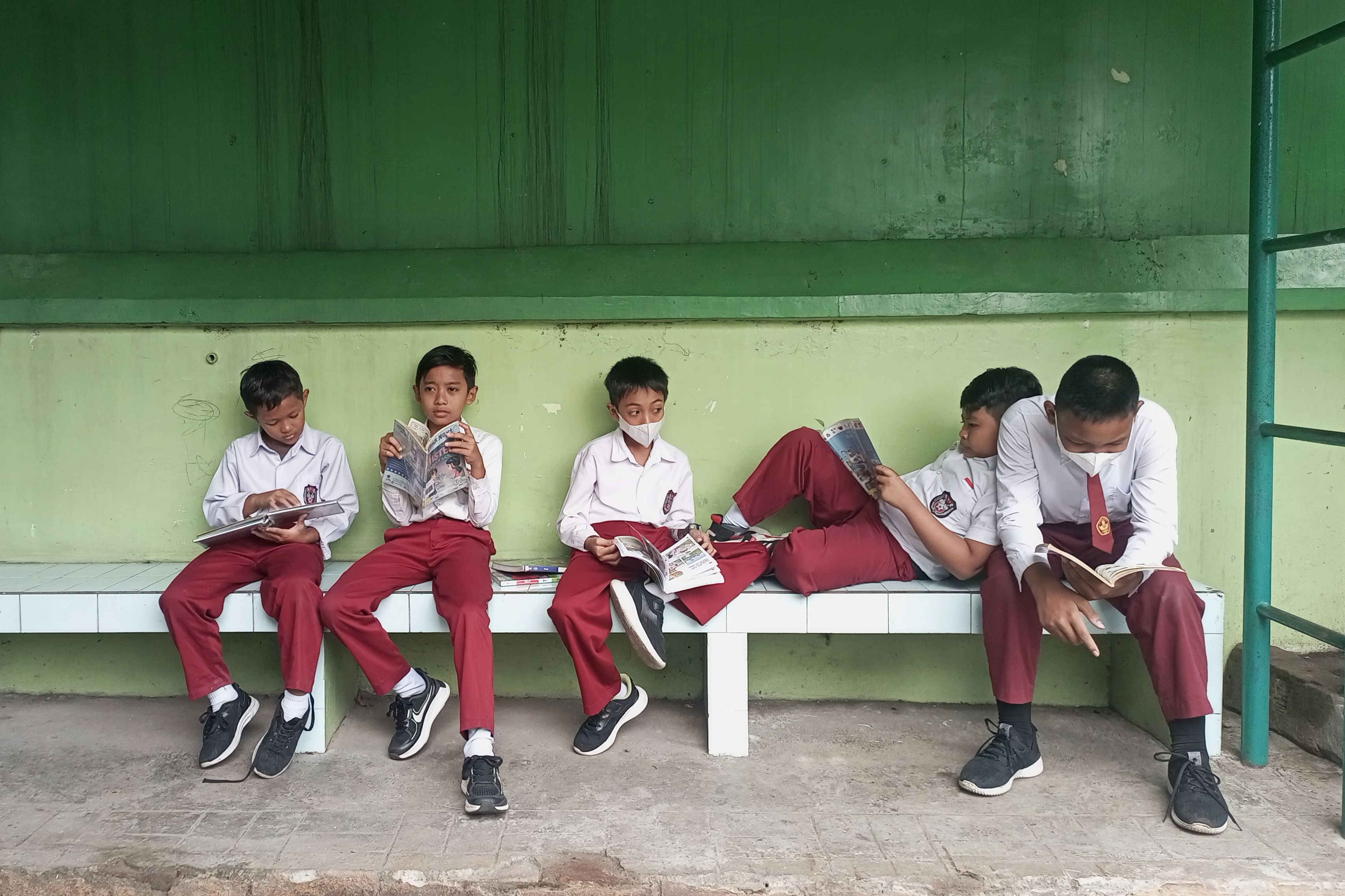 Sejumlah pelajar SD Negeri Jetisharjo membaca buku yang disediakan perpustakaan keliling Puspita (Perpustakaan Alternatif Kota Yogyakarta) di halaman sekolah mereka, Kota Jogja, kemarin (20/8).