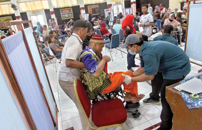 Petugas mengukur tubuh penyandang disabilitas untuk pembuatan kursi roda saat kegiatan pelayanan Jamkesus (Jaminan Kesehatan Khusus), di SLB Negeri Pembina Kota Jogja, Kamis (21/8/2025).