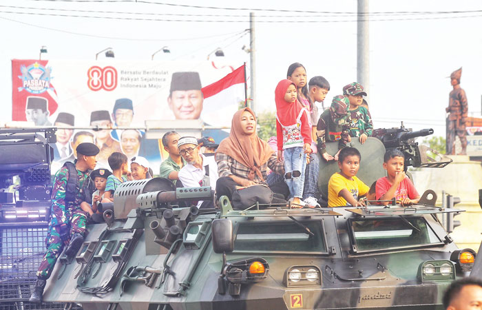 Warga menaiki kendaraan militer saat parade Independence Day Military Expo 2025 di kawasan Denggung, Sleman, Jumat (22/8/2025).