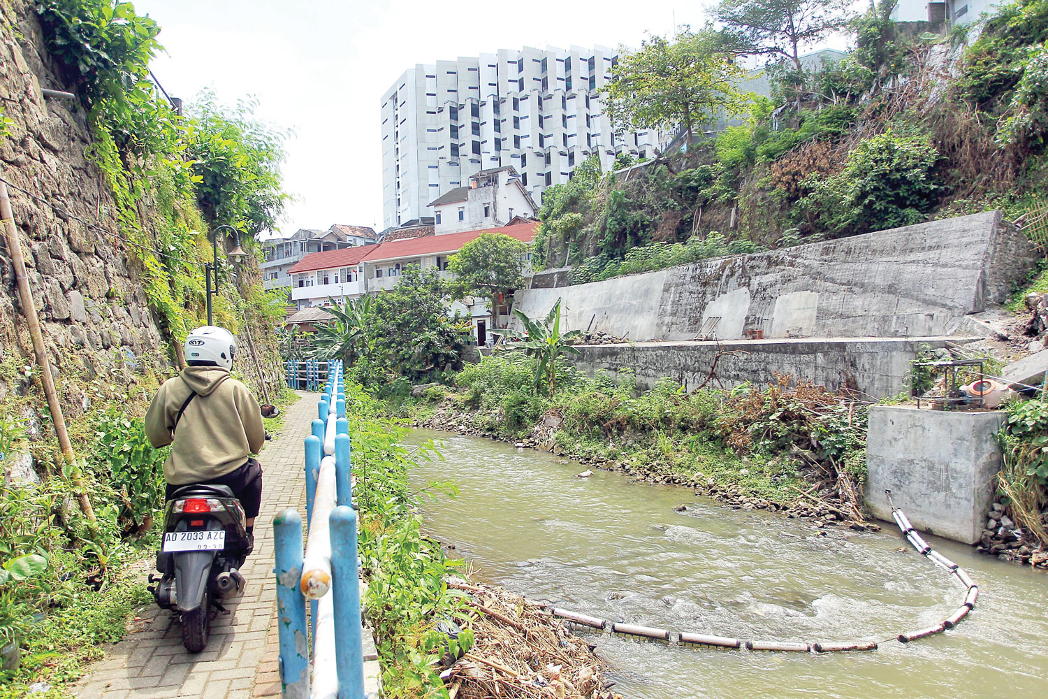 Warga melintas di tepi Sungai Code wilayah Jetisharjo, Cokrodiningratan, Kemantren Jetis,  kemarin (26/8).