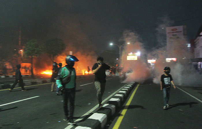 Pengunjuk rasa menghindari efek dari gas air mata yang ditembakkan polisi saat melakukan aksi di depan Mapolda DIY, Jumat (29/8/2025).