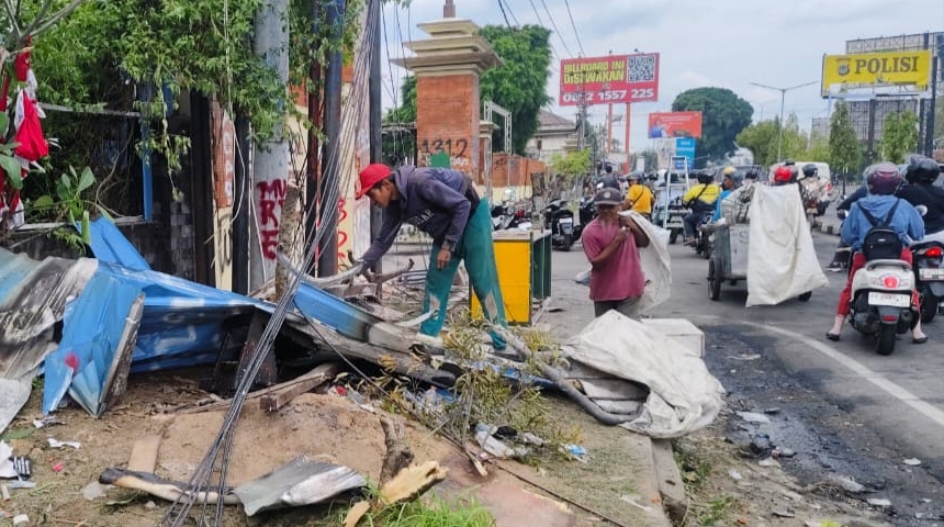 Seorang pemulung memunguti barang yang masih bisa dijual di depan Mapolda DIY usai aksi massa semalaman (30/8/2025).