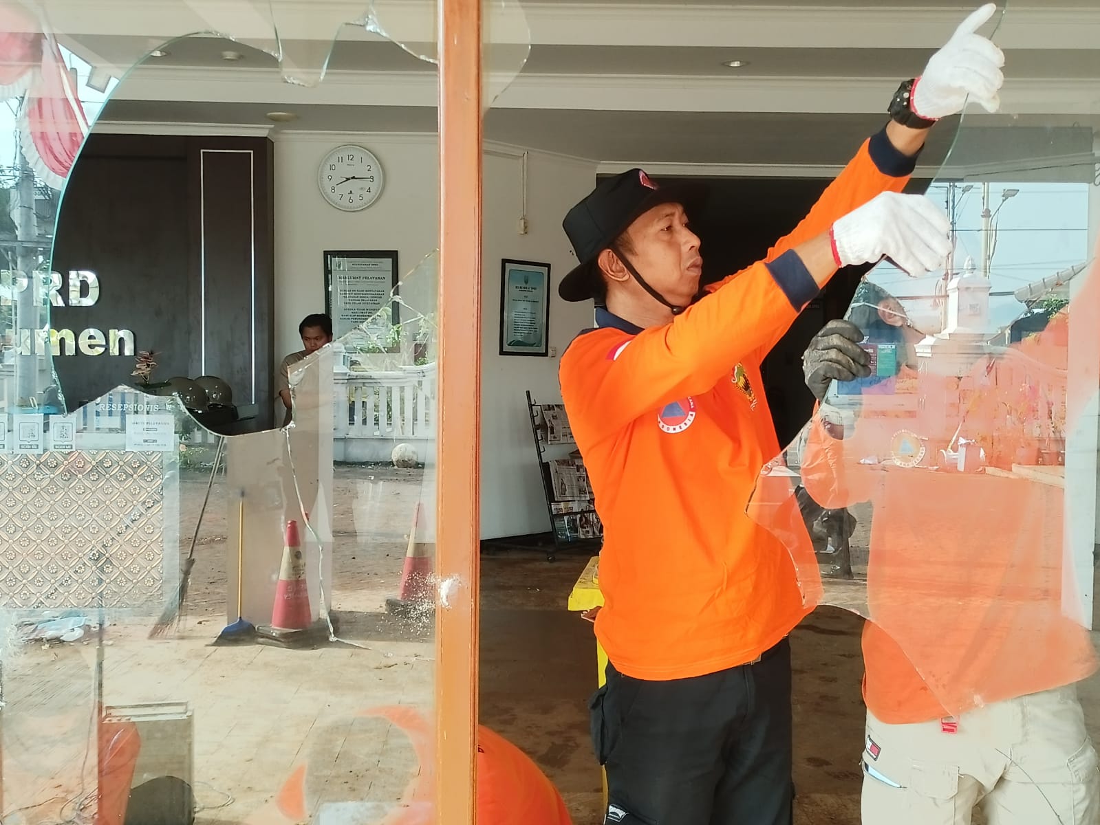 Petugas gabungan membersihkan puing-puing dari sisa aksi demonstrasi yang terjadi di gedung DPRD Kebumen.
