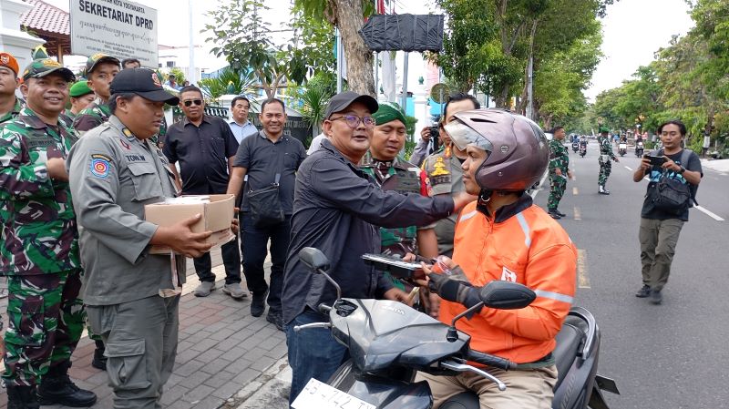 Unsur Forkopimda Kota Jogja yang terdiri dari Satpol PP, TNI, dan DPRD saat membagikan makanan ke masyarakat pada Senin (1/9).