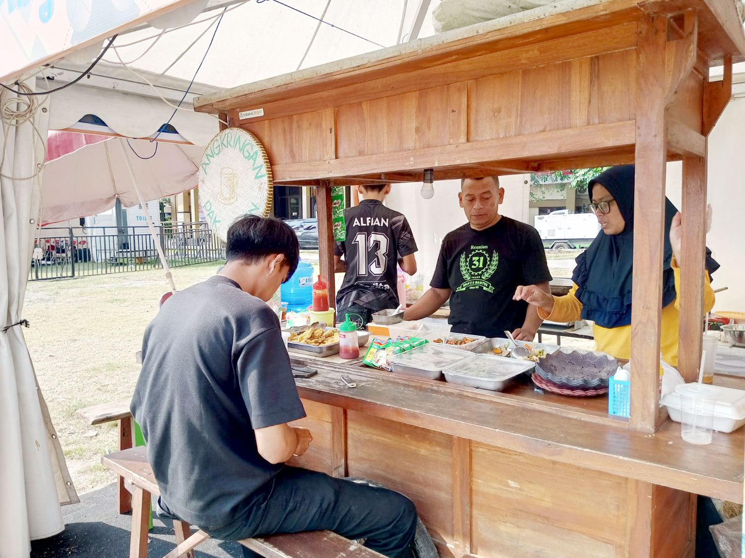 LARIS: Tri Aprilia sedang melayani pembeli angkringan di stand bazar Gebyar Keistimewaan, Minggu (31/8).