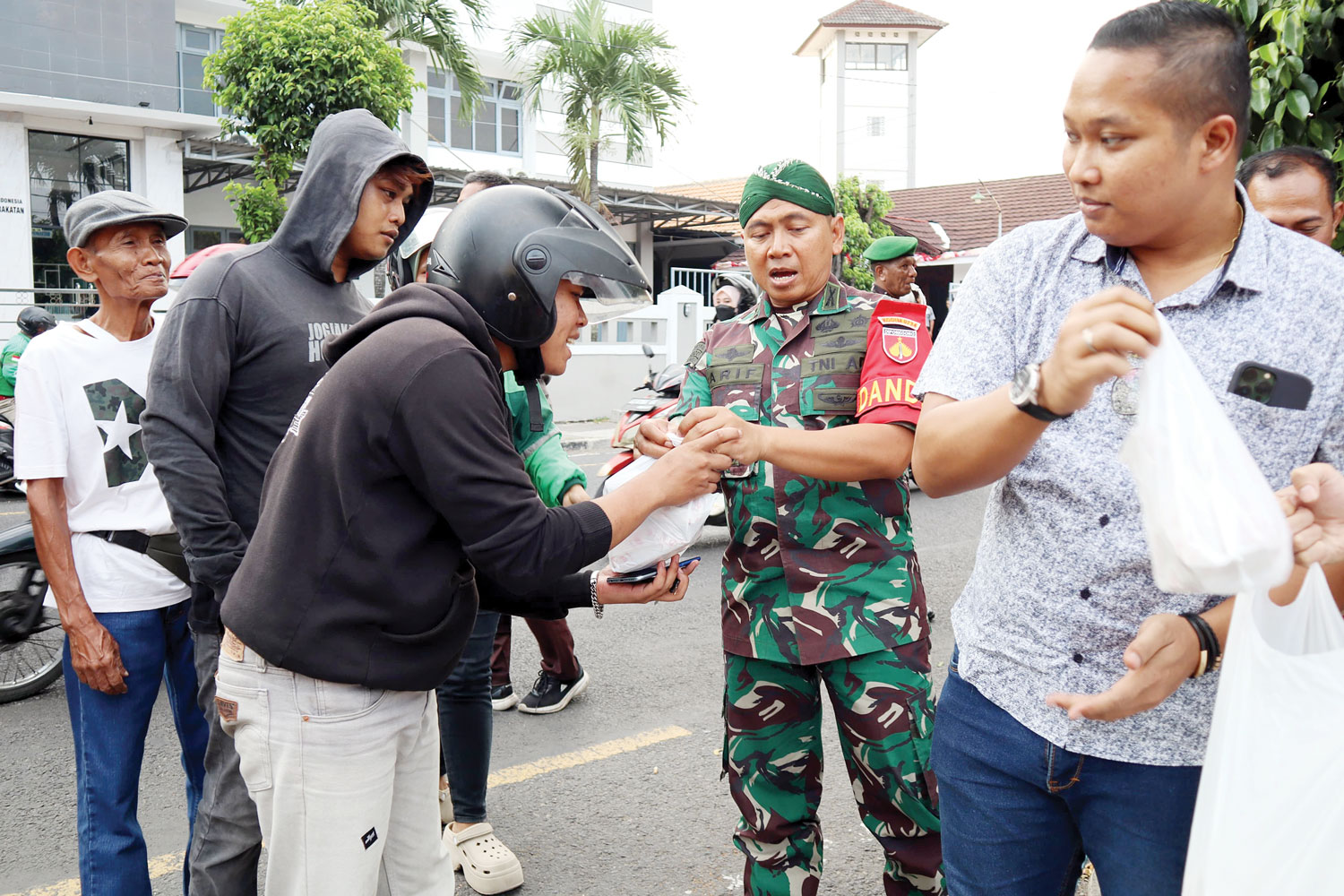 MENJAGA KEKONDUSIFAN: Personel Kodim 0734 dan anggota DPRD Kota Jogja saat membagikan nasi gratis di Jalan Tamansiswa, (2/9).