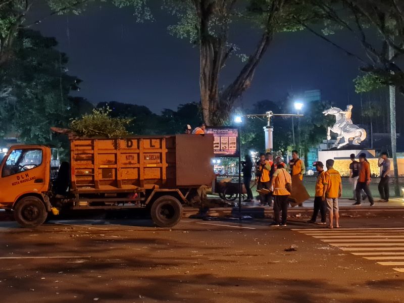 BEBERSIH: Petugas kebersihan menyisir kawasan alun-alun usai kericuhan berlangsung Jumat malam (29/8).