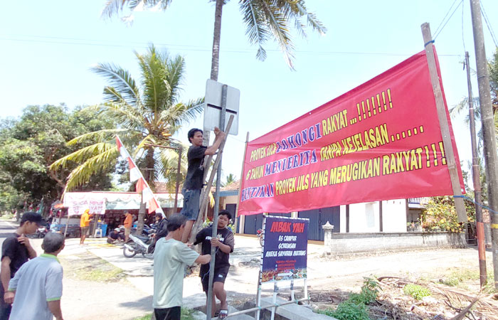 KEKECEWAAN BERTAHUN-TAHUN: Warga Kalurahan Karangwuni memasang banner berisi keluhan atas ketidakjelasan ganti untung proyek pelebaran JJLS, Rabu (3/9).
