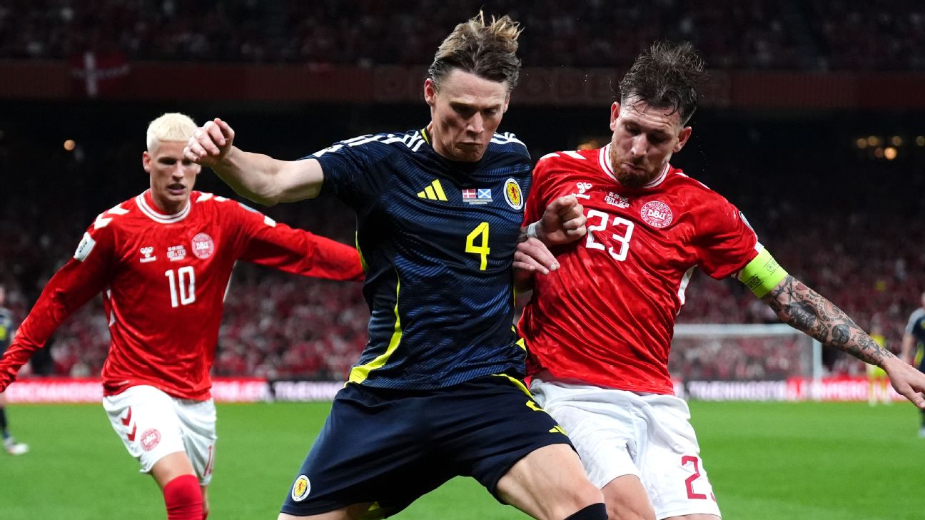 Pemain Skotlandia, Scott McTominay coba melindungi bola dari sergapan dua pemain Denmark