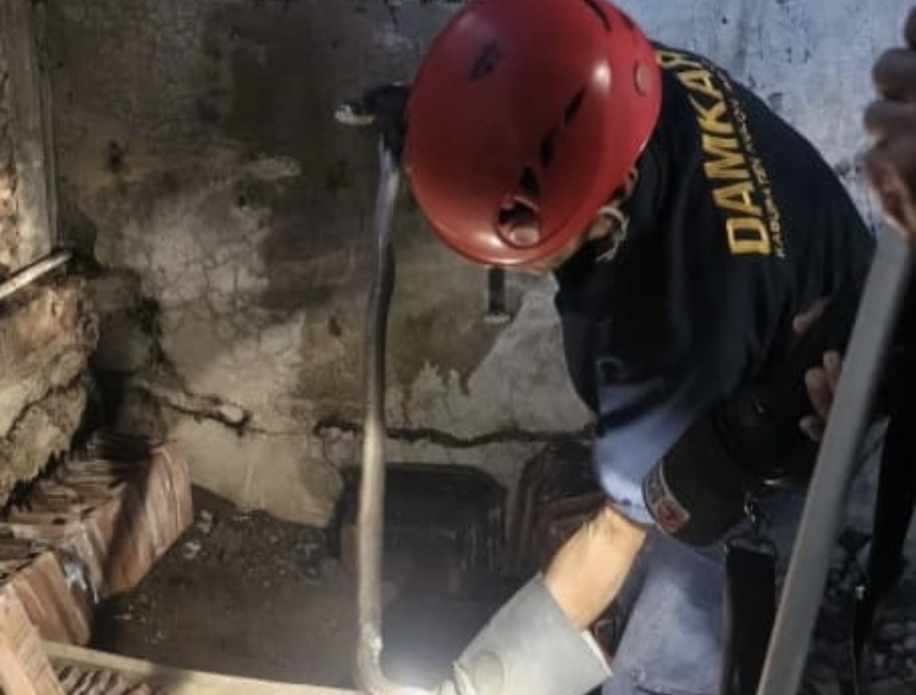 EVAKUASI: Personel melakukan penangkapan ular yang mengganggu aktivitas warga.