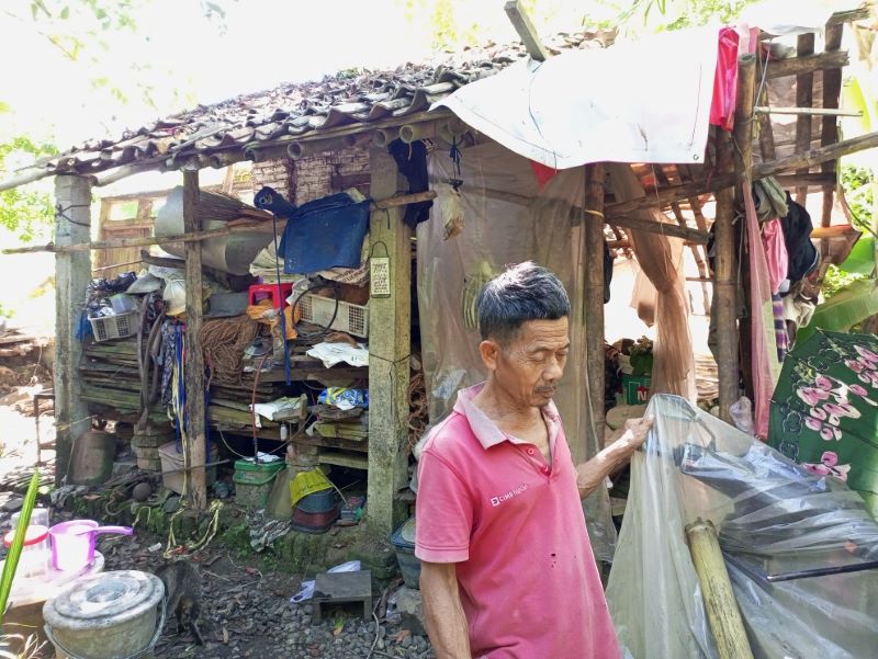 CERMIN KEMISKINAN: Dulsomad, 63, warga Desa Rantewringin, Kecamatan Buluspesantren tinggal di rumahnya dengan atap spanduk bekas.