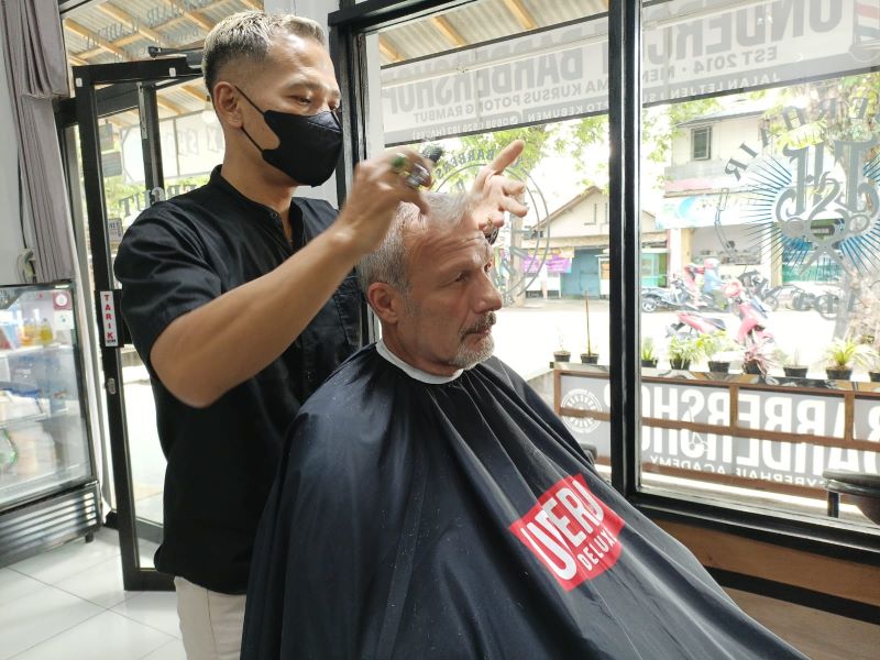 TELATEN: Anggota Persatuan Pangkas Rambut Kebumen (PPRK) melayani pelanggan yang merupakan warga negara asing (WNA).