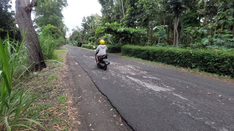 MLIPIR: Kendaraan roda dua memelankan kecepatannya saat melewati lubang di  Jalan Cerme-Gotakan, Kalurahan Gotakan, Kapanewon Panjatan, Kulon Progo .