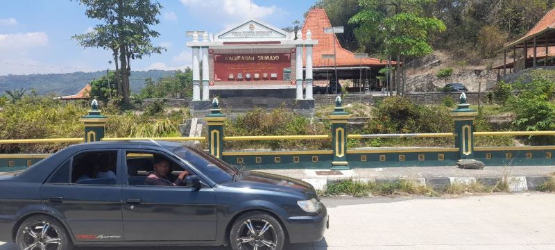 Sebuah mobil melintas di jalan depan Kalurahan Srimulyo, Piyungan, Bantul.
