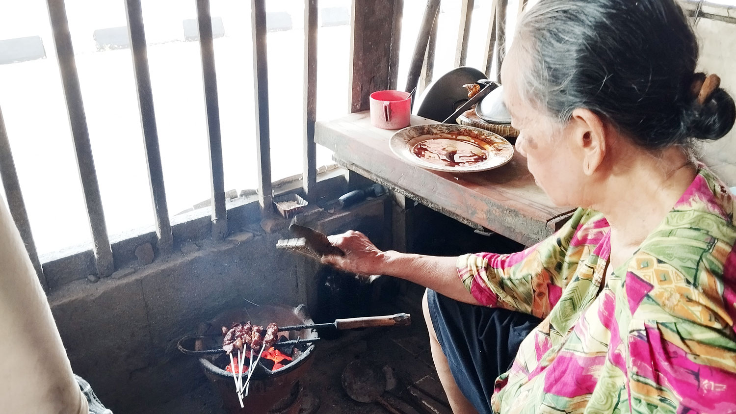 PEDAS: Sumarni sedang membakar sate di warungnya di Ring Road Selatan, Menayu Kidul, Tirtonirmolo, Kasihan, Bantul.