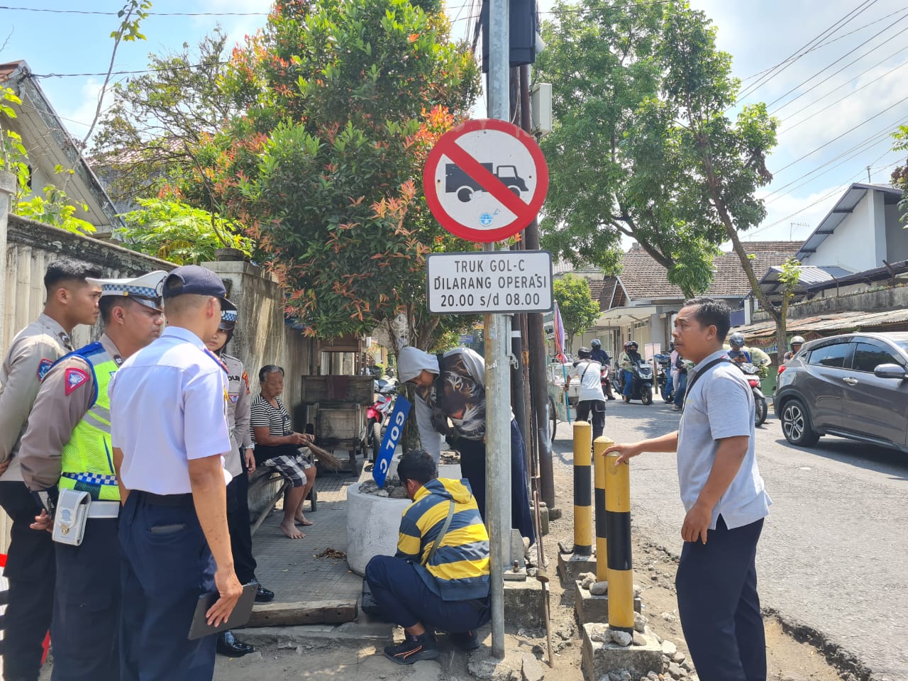 Petugas memasang papan informasi terkait jam operasional truk golongan C di Simpang Empat Sayangan, Muntilan, Rabu (24/9/2025).