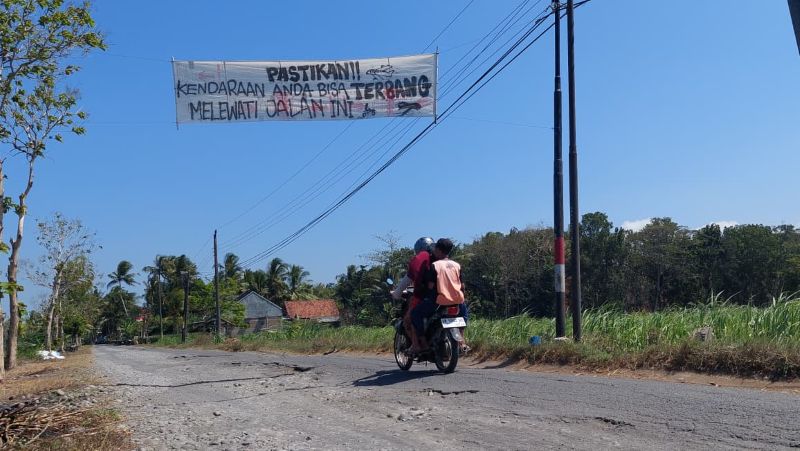 PROTES: Jalan Cerme-Demangan rusak parah membuat masyarakat memasang spanduk protes.&nbsp;