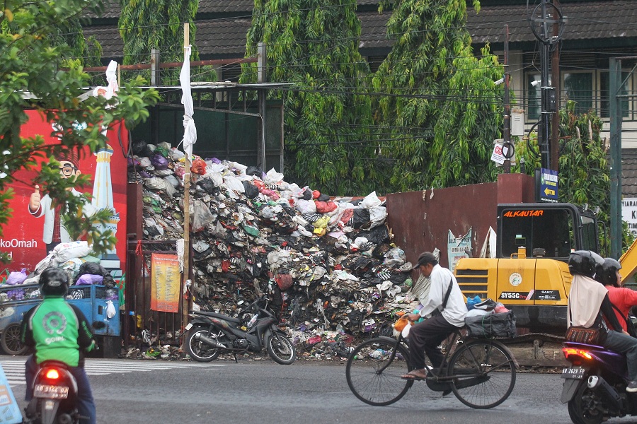 Pengendara melintas di depan depo yang kondisinya masih menumpuk di Jalan Brigjend Katamso, Kota Jogja, Senin (29/9/2025).
