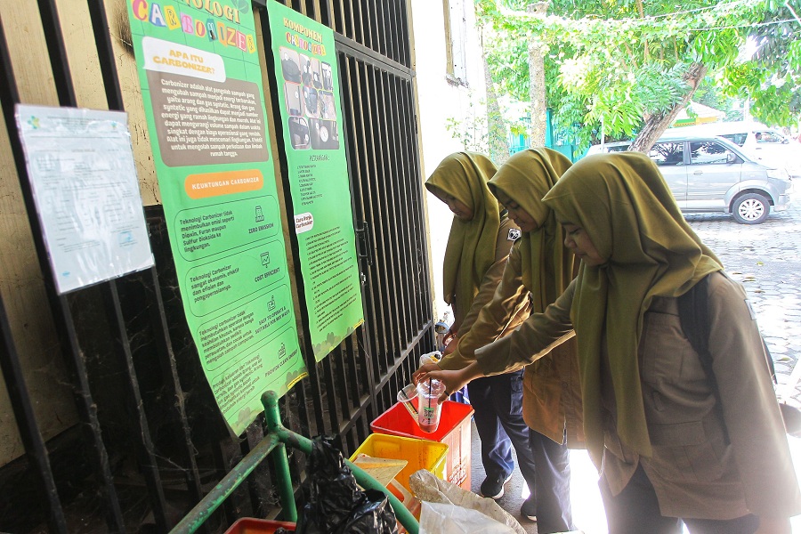 Pelajar membuang sampah pada tempat yang tersedia di area bank sampah SMP Negeri 5 Kota Jogja, Rabu (1/10/2025).