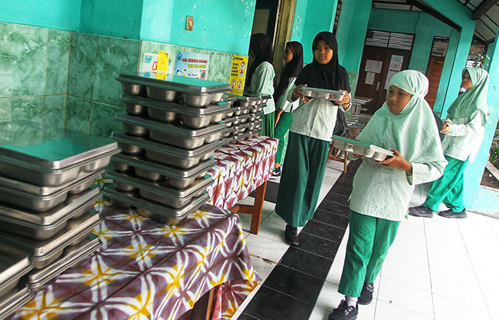 AMBIL JATAH: Sejumlah pelajar menyantap menu MBG yang disediakan oleh Satuan Pelayanan Pemenuhan Gizi (SPPG) Unisa di SD Negeri Serangan, Jogja, kemarin (3/10).
