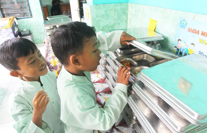 PERHATIKAN SOP: Pelajar menyantap menu Makan Bergizi Gratis (MBG) yang disediakan oleh Satuan Pelayanan Pemenuhan Gizi (SPPG) Unisa di SD Negeri Serangan, Kota Jogja, Jumat (3/10).