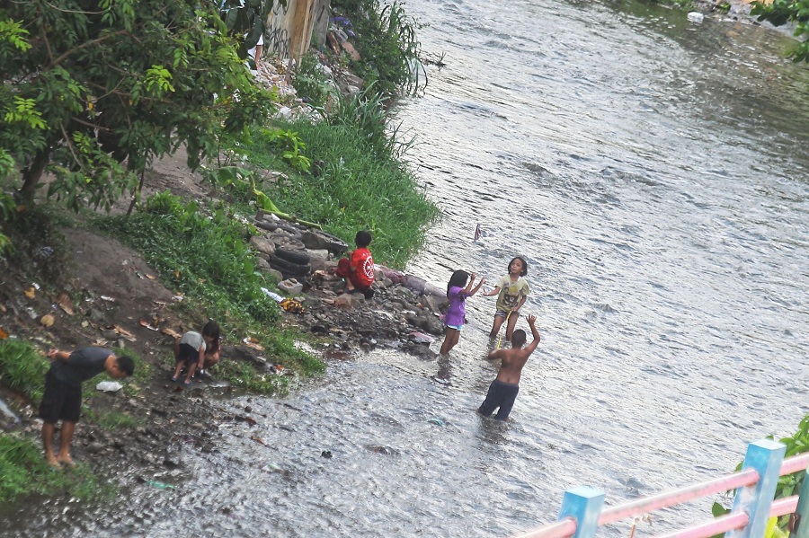 Anak-anak bermain di Sungai Code sekaligus mendinginkan badan saat suhu panas melanda wilayah Kota Jogja, Kamis (9/10/2025).