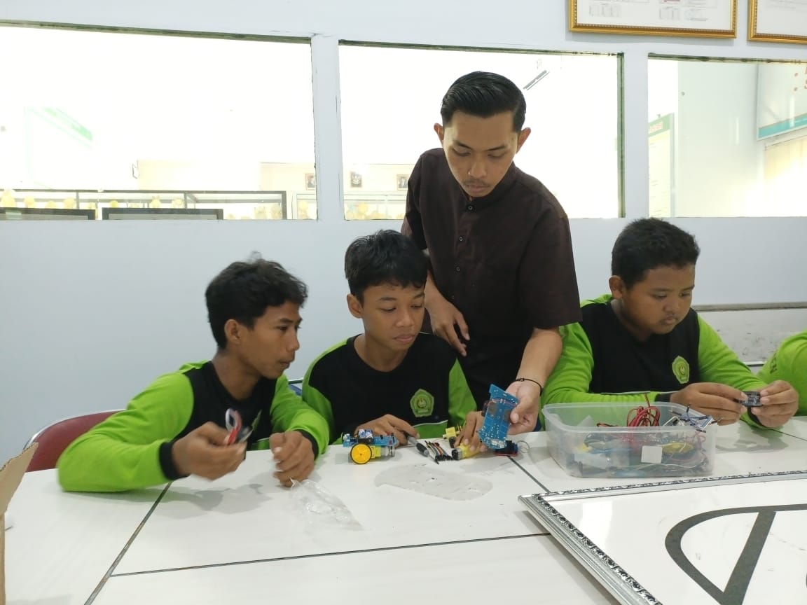 KREATIF: Siswa MTsN 8 Kebumen menunjukkan hasil karya robot berbasis Internet of Things (IoT). Dari karya tersebut menghantarkan madrasah di Kecamatan Gombong ini lolos dalam ajang OMI 2025