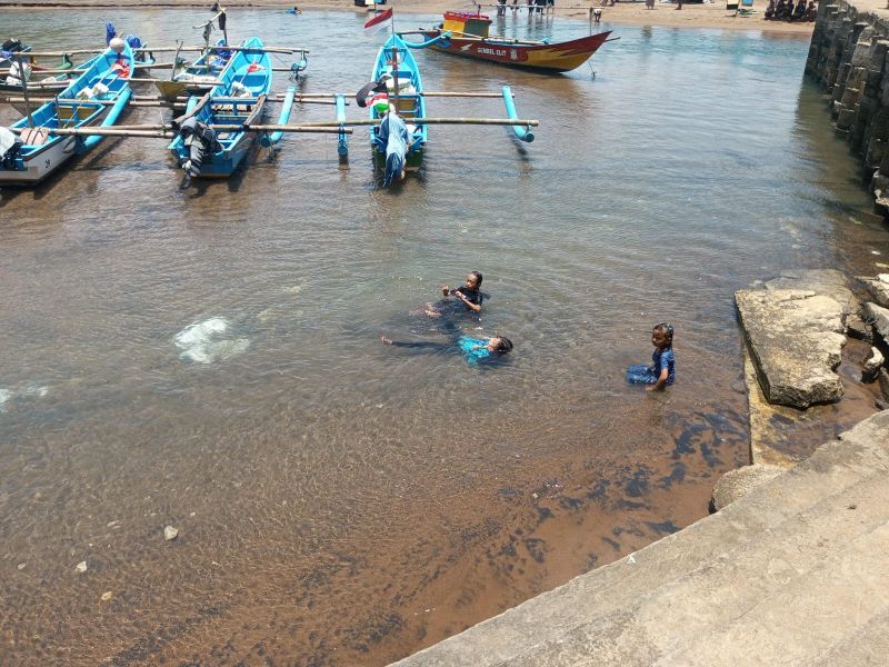 ASYIK: Wisatawan sedang bermain di area sungai yang mengarah ke Pantai Baron.