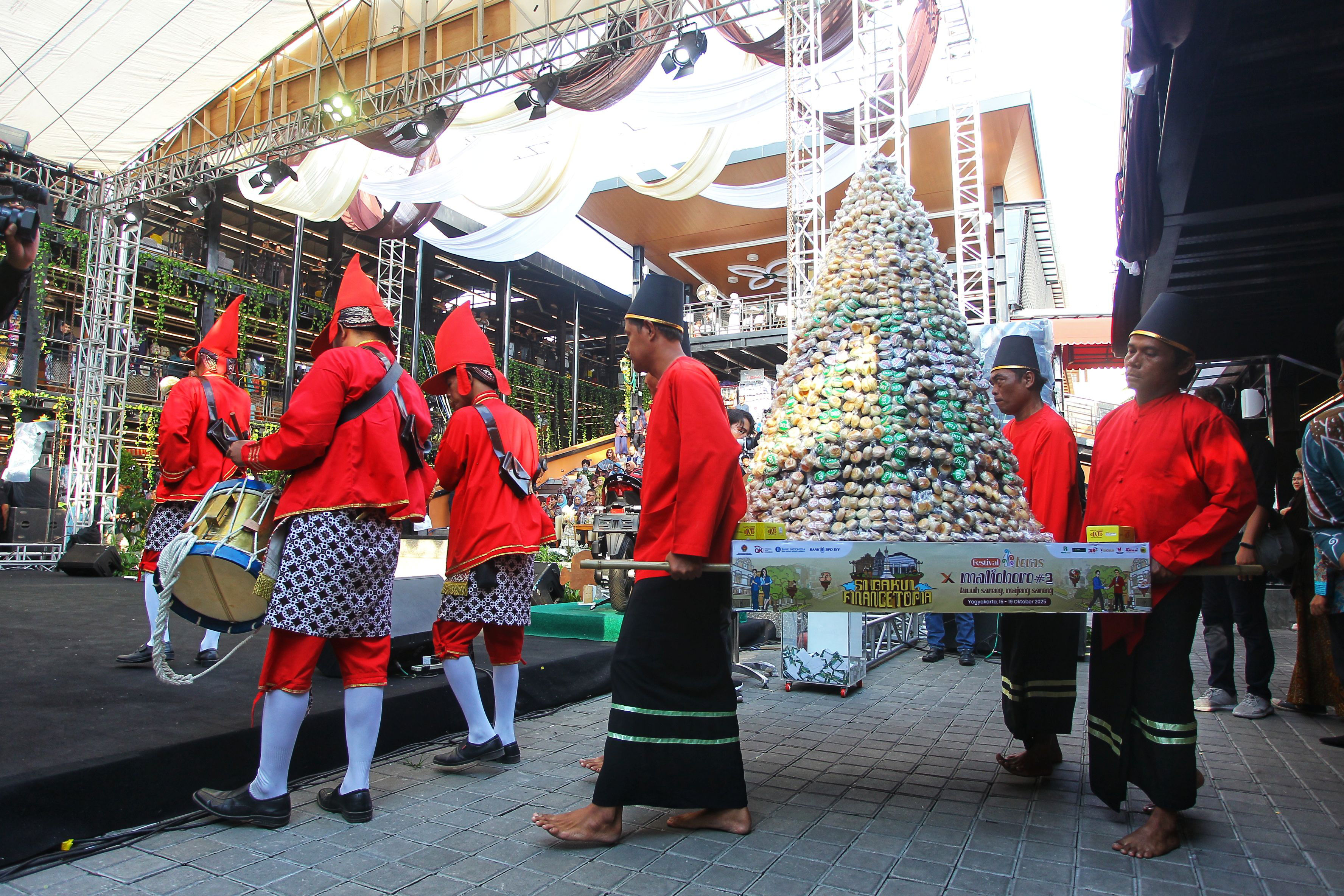 Bregada mengarak gunungan berisi kue bakpia dalam SiBakul Financetopia X Festival Teras Malioboro #3 bertemakan &ldquo;Satu Festival, Sejuta Cerita&rdquo;, di Teras Malioboro Beskalan, Kota Jogja, kemarin (16/10)