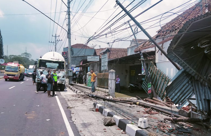 EVAKUASI: Petugas kepolisian mengevakuasi truk Hino yang menabrak rumah di simpang empat Secang, Kamis (16/10).