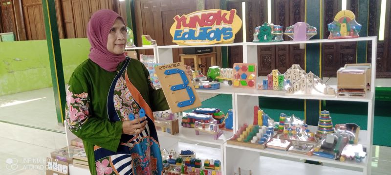 Perajin mainan anak-anak Siti Rahma Yuliyati sedang memegang mainan yang terbuat dari kayu Senin (20/10)