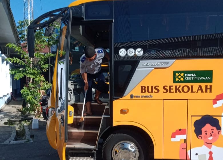 Petugas Dishub Gunungkidul sedang membersihkan bus.