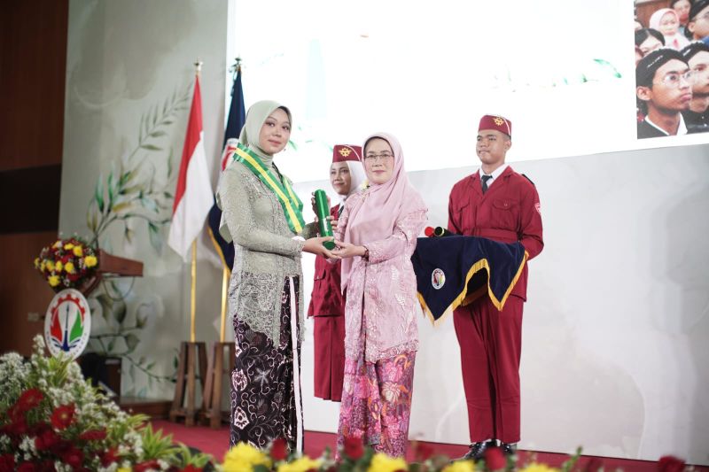 SUKSES: Kepala Sekolah SMK-SMTI Yogyakarta Rr Ening Kaekasiwi saat memberikan bukti kelulusan kepada salah satu wisudawan, Rabu (22/10/2025).