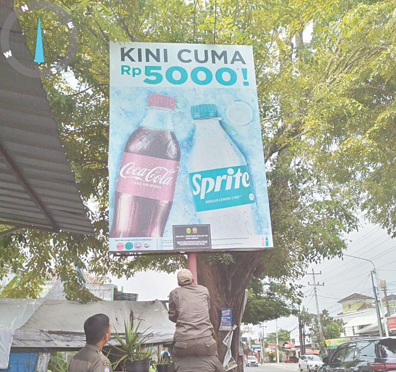 ILEGAL: Satpol PP Bantul sedang memasang surat peringatan di reklame yang tidak berizin.