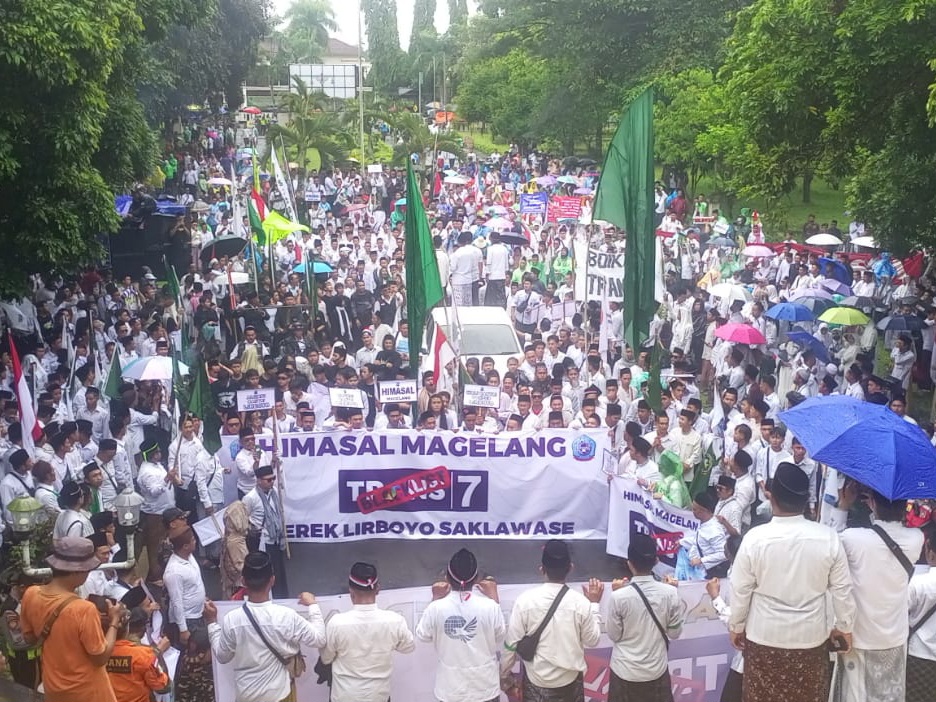 Peserta aksi membentangkan spanduk