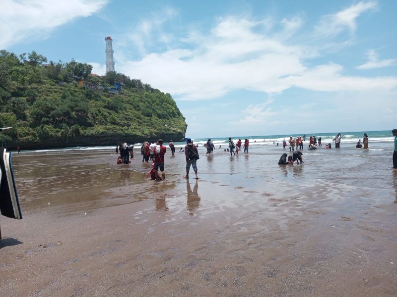 ANTUSIAS: Wisatawan asik bermain di bibir Pantai Baron, Sabtu (18/10/2025) pekan lalu.