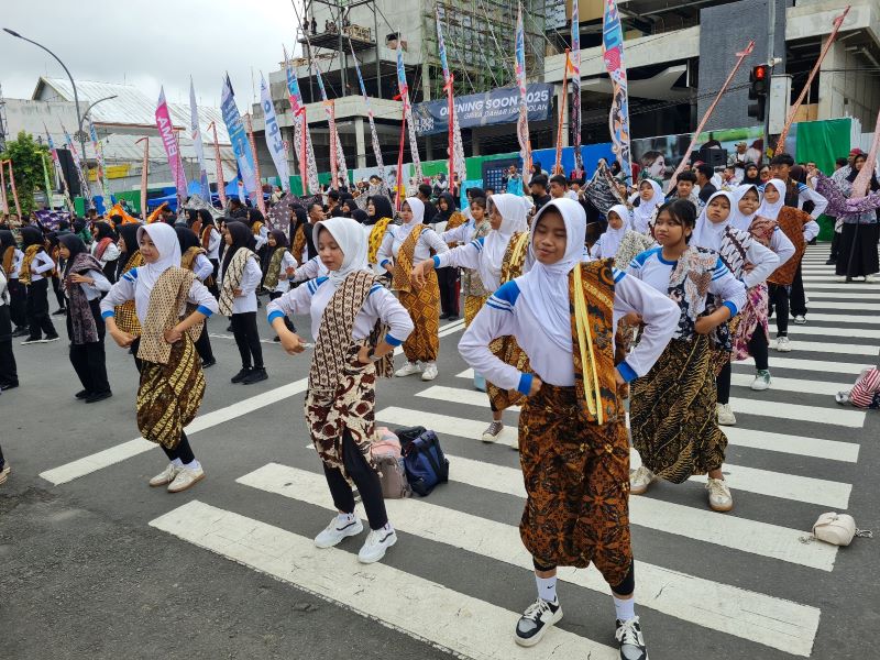 ANTUSIAS: Ribuan warga Kota Magelang kompak menari dengan membawa kain batik di alun-alun Minggu (26/10).