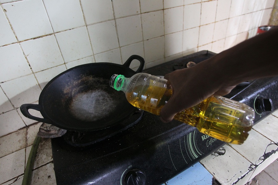 Warga menuang minyak goreng untuk keperluan memasak di rumahnya di kawasan Tegalrejo, Kota Jogja, Senin (27/10/2025).