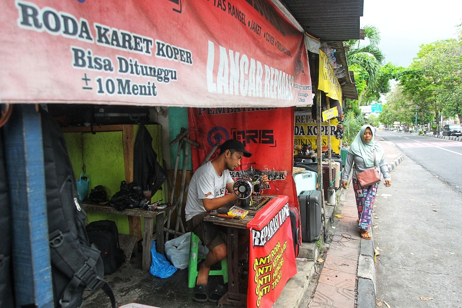 Pekerja mereparasi koper di Jalan Tentara Pelajar, Bumijo, Kota Jogja, Senin (27/10/2025).