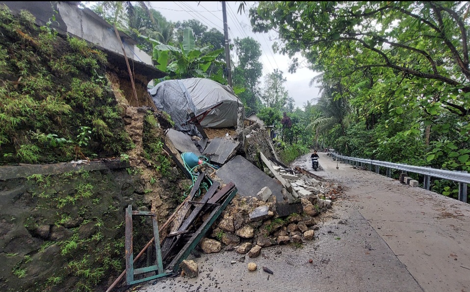 DAMPAK HUJAN: Garasi beserta mobil Yusoko terperosok ke bahu jalan akibat talut ambrol.