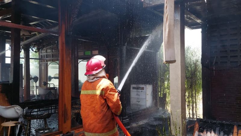 HEROIK: Petugas Damkarmat Kulon Progo menyelamatkan bangunan terbakar.&nbsp;