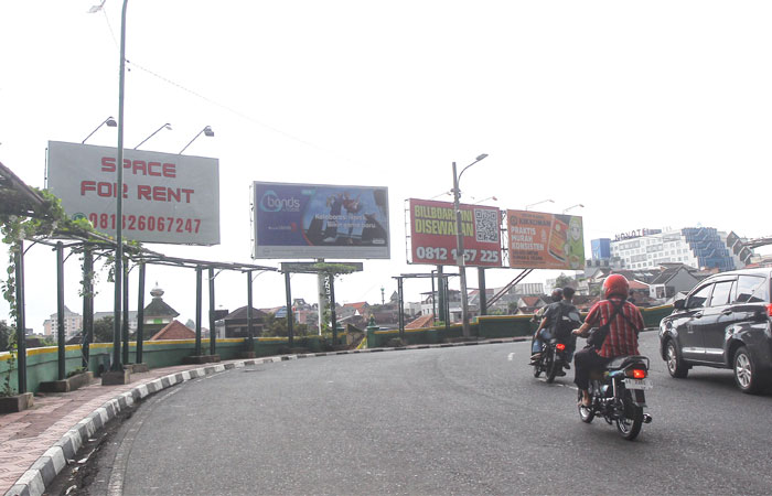 WASPADA: Pengendara kendaraan bermotor melintas di dekat reklame baliho yang terpasang di seputaran Jembatan Kleringan, Kota Jogja, Jumat (31/10).