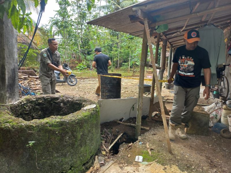 BATAS AMAN: Petugas BPBD Gunungkidul memasang garis aman di area tanah ambles Padukuhan Telong Wareng, Karangmojo.