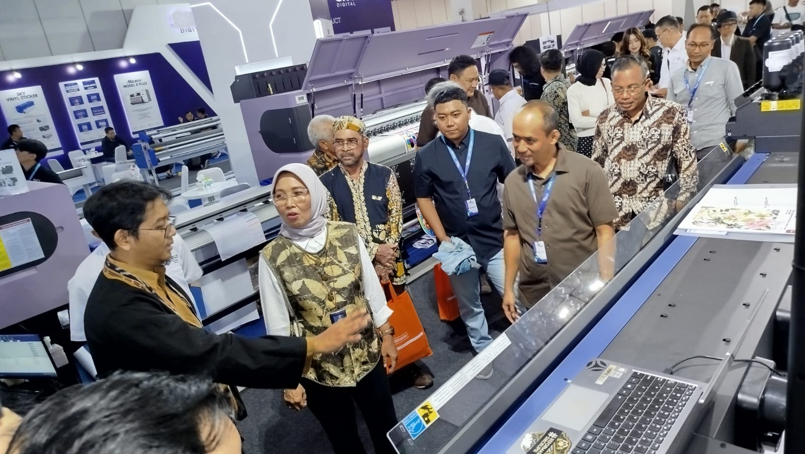 Bryan Whildan Arsaha (kiri) menjelaskan salah satu mesin printing kepada Yuna Pancawati dalam Indonesia Grafika Expo 2025, di Hall A JEC, Rabu (5/11/2025).