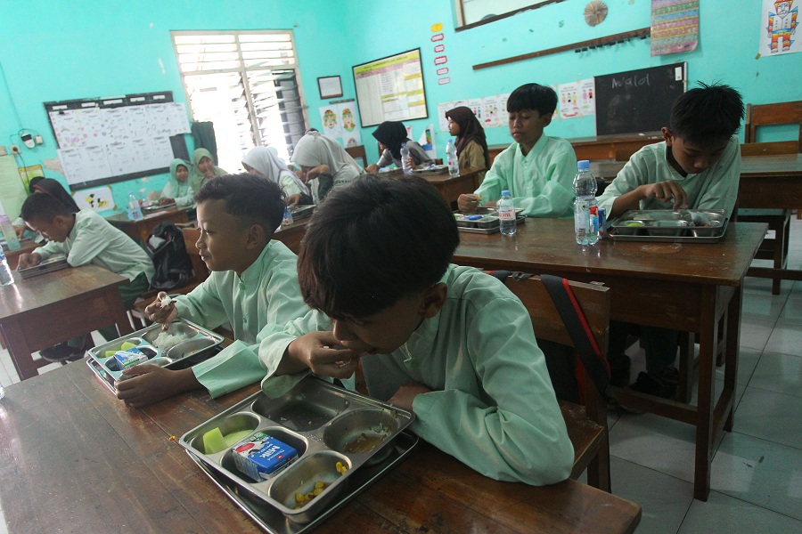Sejumlah pelajar menyantap menu Makan Bergizi Gratis (MBG) yang disediakan oleh Satuan Pelayanan Pemenuhan Gizi (SPPG) Unisa, di SD Negeri Serangan, Kota Jogja, Jumat (3/10/2025).