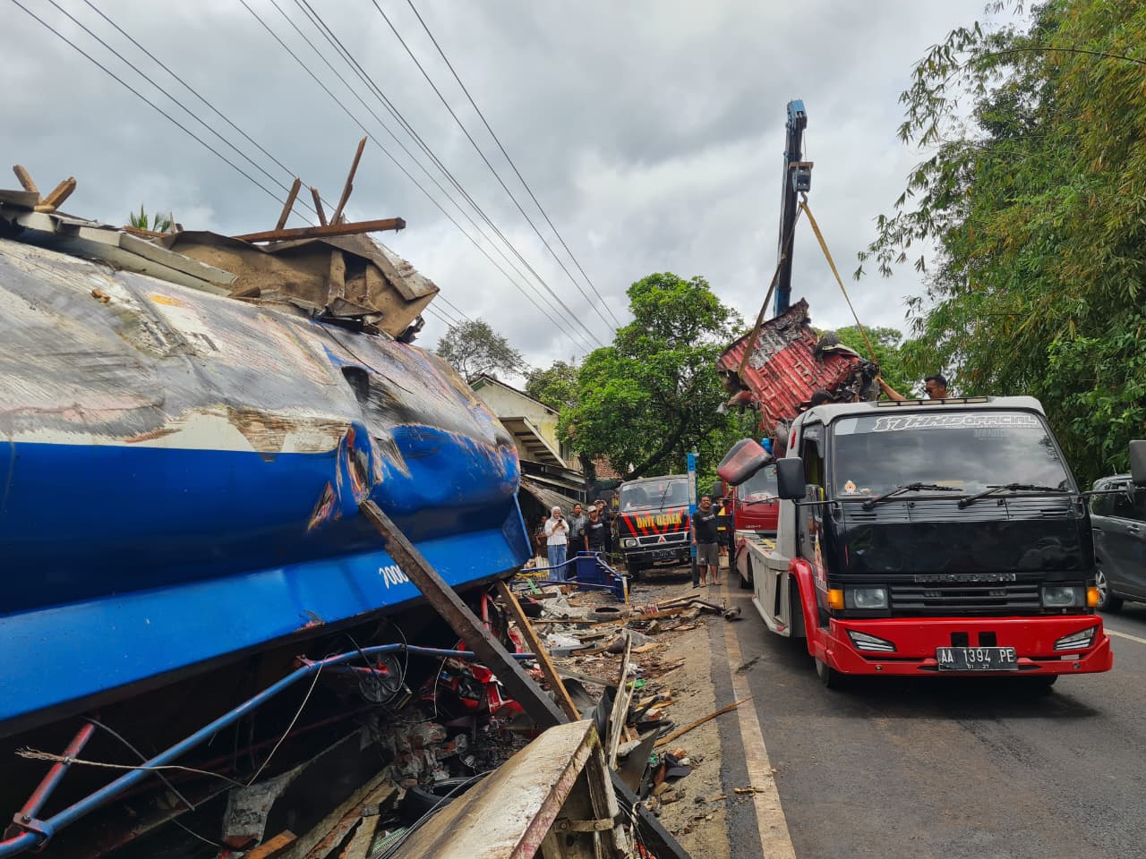 PEMBERSIHAN: Petugas gabungan berupaya mensterilkan badan jalan dan puing-puing kendaraan di depan Pasar Kalijambe, Selasa (11/11/2025).