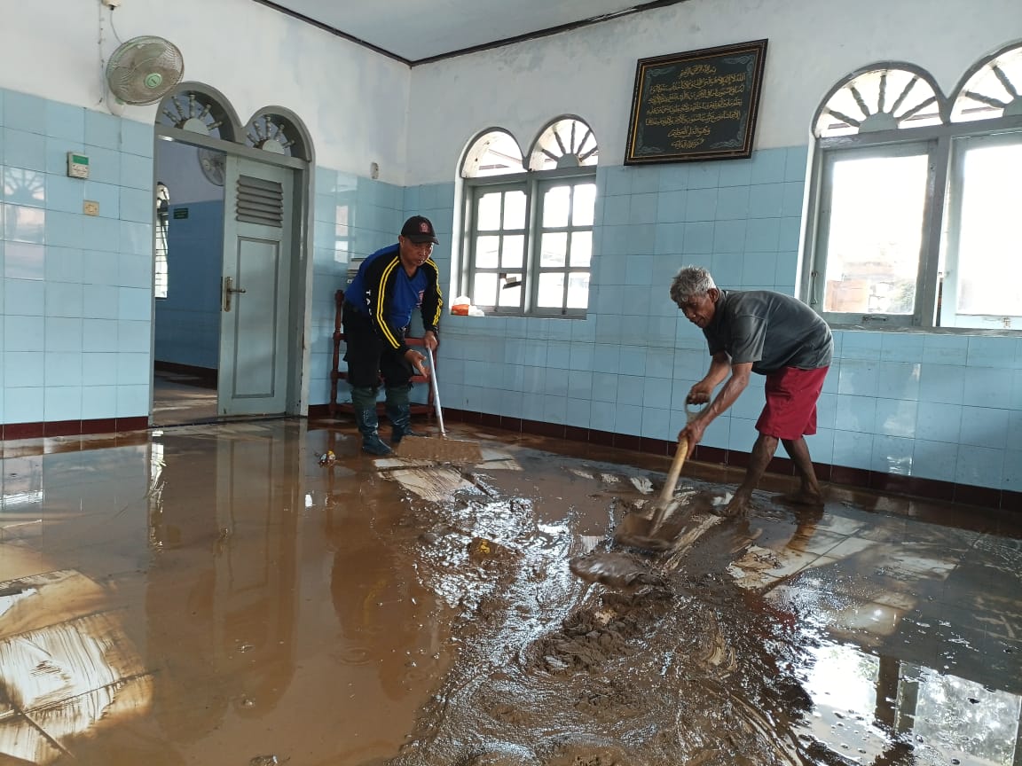 Warga Kelurahan Panjatan, Kecamatan Karanganyar membersihkan sisa material yang terbawa arus akibat tanggul Sungai Karangayar jebol pada pada Minggu (9/11) malam.