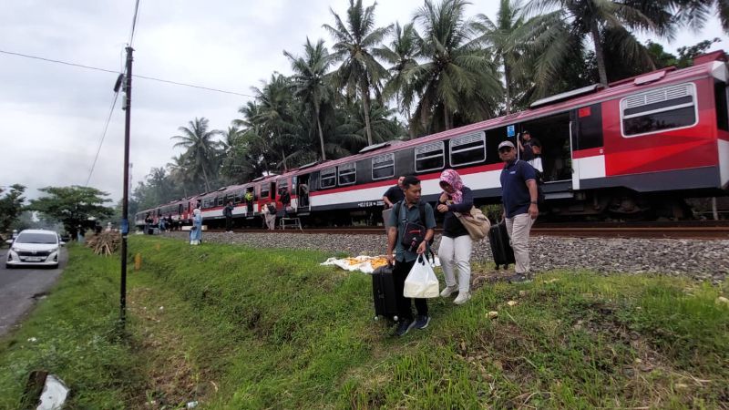 BERGEGAS: Penumpang kereta menyebrangi rel untuk beralih ke moda transportasi lain.&nbsp;