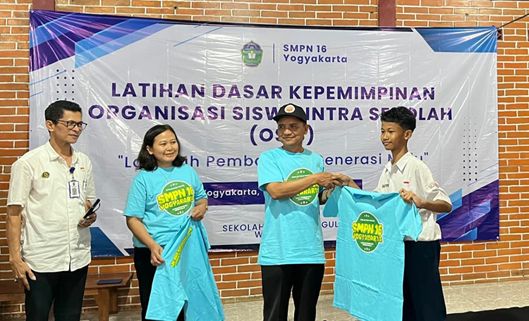 PEMBUKAAN: Kepala Bidang Pembinaan SMP Disdikpora Kota Yogyakarta Hasyim (dua dari kanan) menyerahkan kaus pada peserta LDK SMP Negeri 16 Yogyakarta, (12/11/2025).