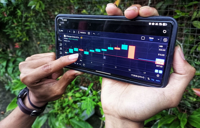 MELEK FINANSIAL DIGITAL: Anak muda generasi Z mengamati grafik pergerakan harga saham menggunakan ponselnya, kemarin (14/11).